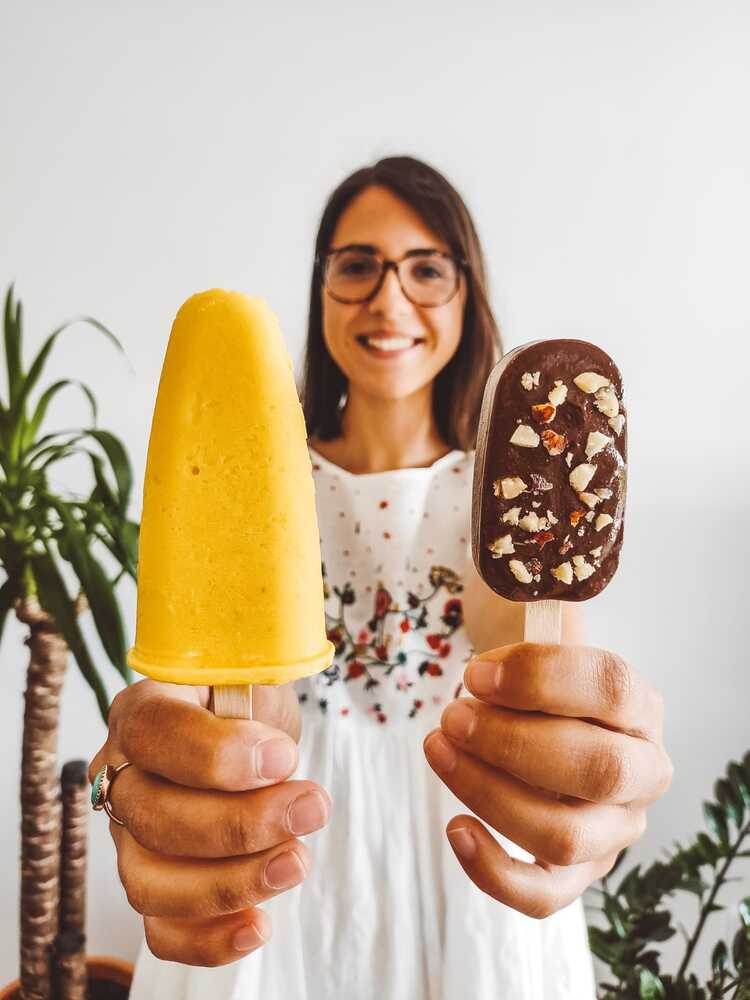 Menina a sorrir com dois gelados vegan nas mãos